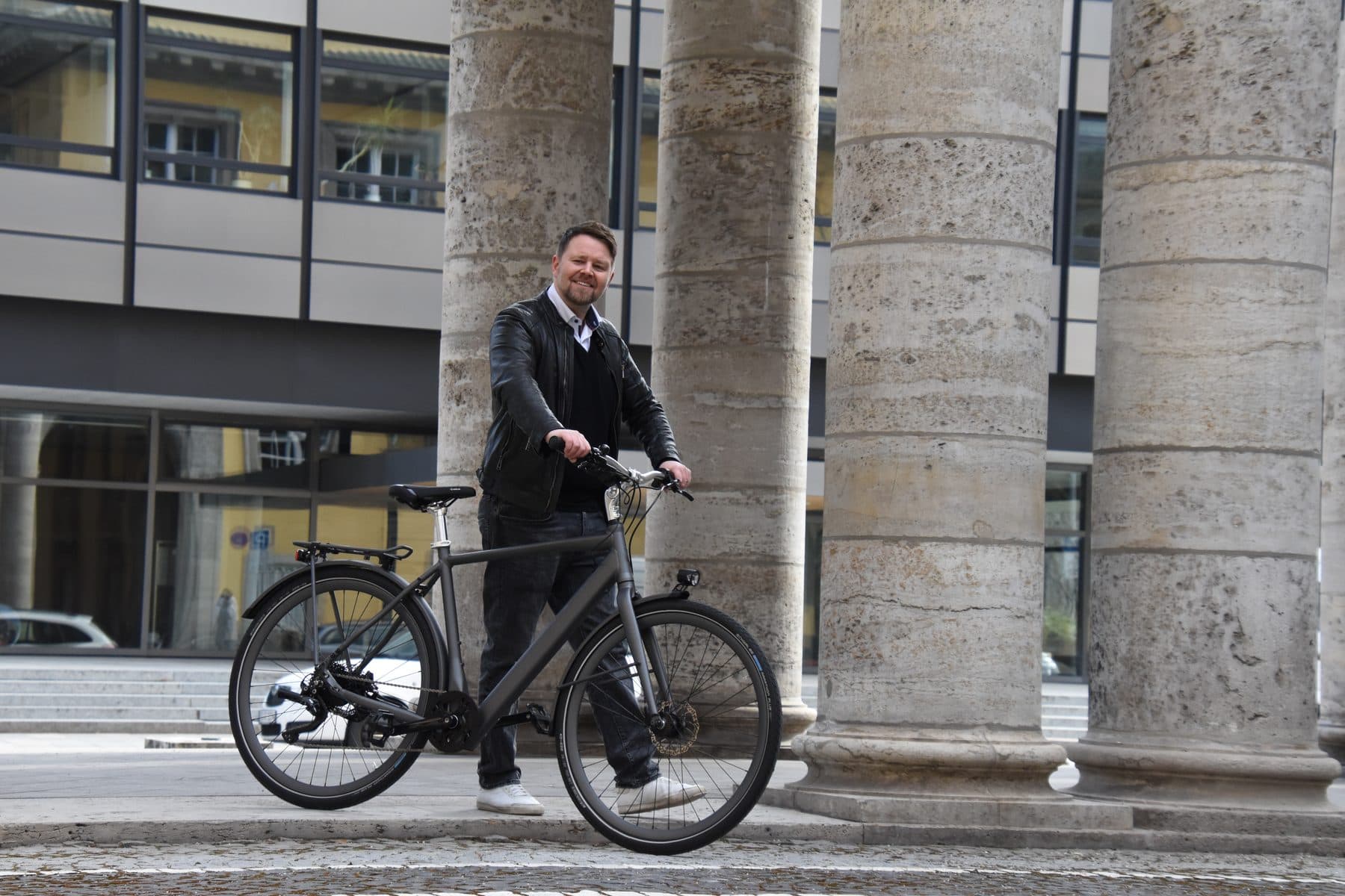 Kunde mit einem bikeOmotion-Rad vor den Säulen am Münchner Königsplatz