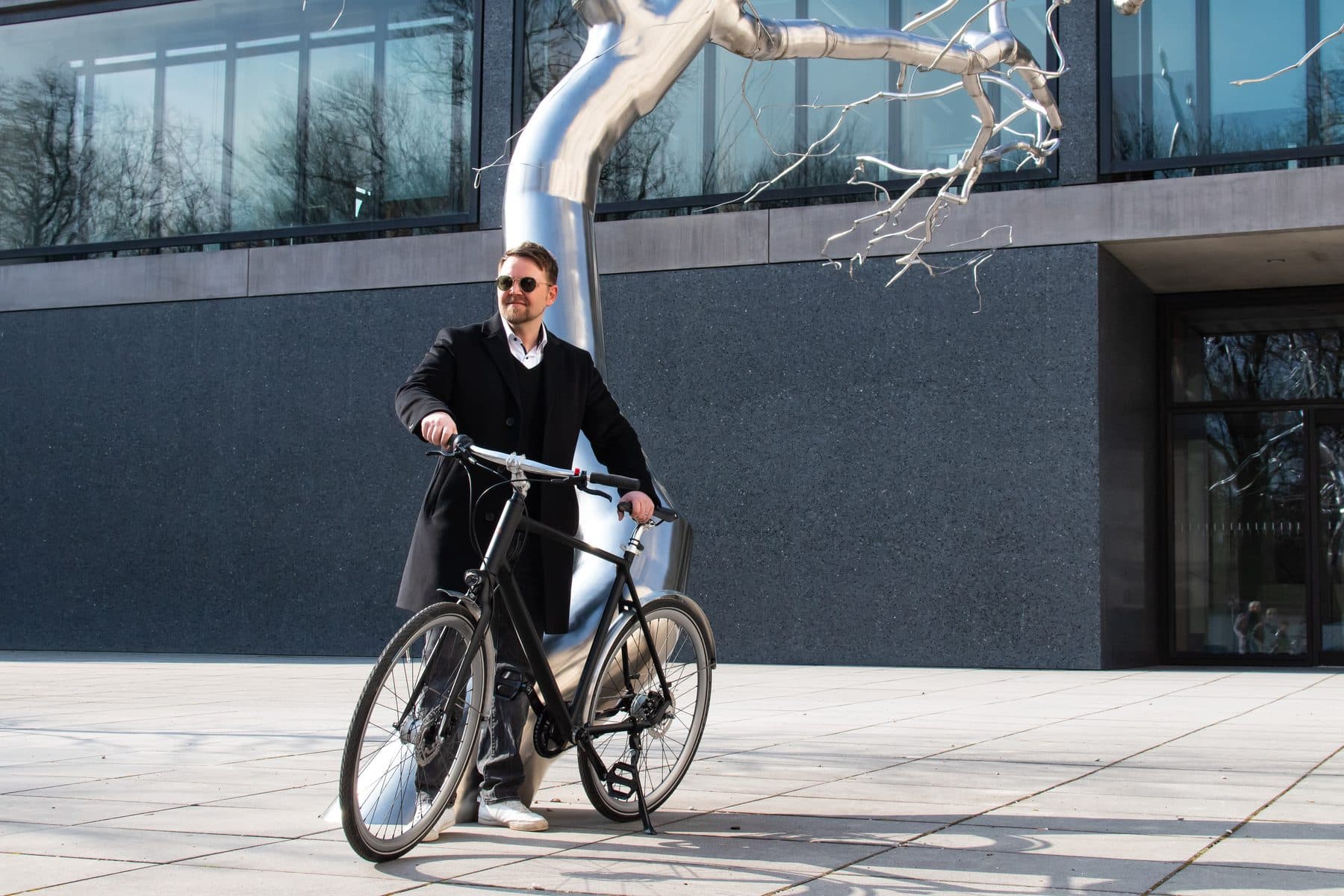 Radfahrerin vor einer modernen Fassade in München
